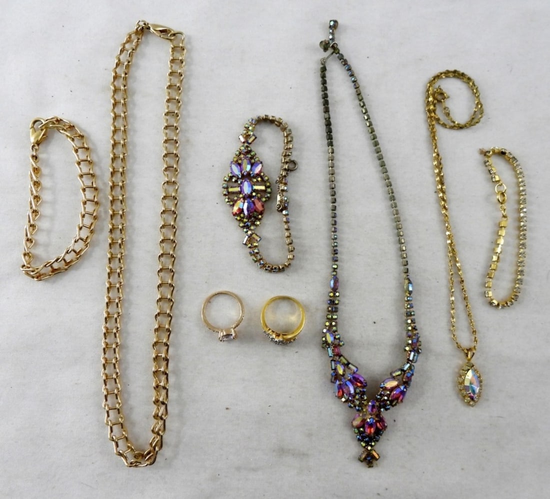 COLORFUL AND GOLD TONE SPARKLING LOT: 2 RINGS (SIZE 6 AND 7), 2 DIAMOND LIKE BRACELETS, 2 NECKLACES, AND 1 GOLD TONE NECKLACE AND BRACELET SET