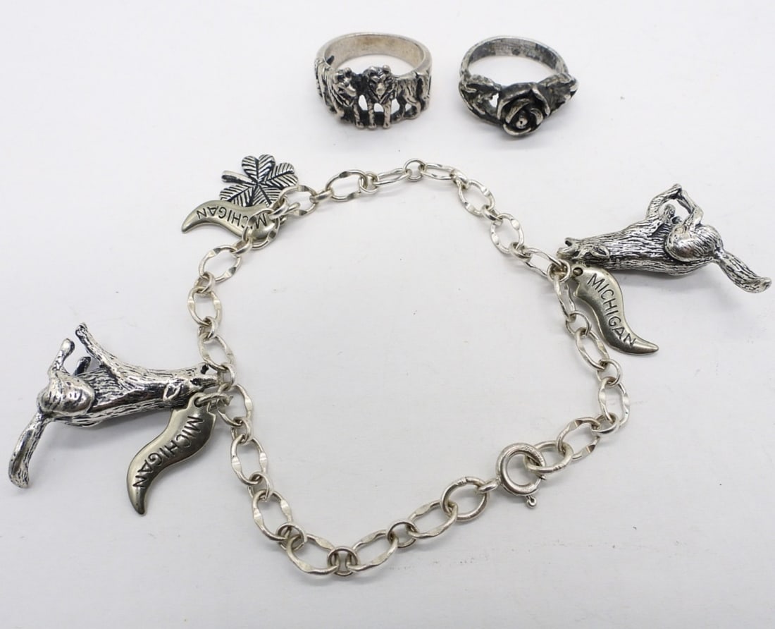 WOLF CHARM BRACELET & RINGS - STERLING: STERLING CHARM BRACELET WITH WOLVES, CLOVER & MICHIGAN CHARMS, 8". WOLF RING SIZE 7. ROSE RING SIZE 5.5. 21.5 DWT