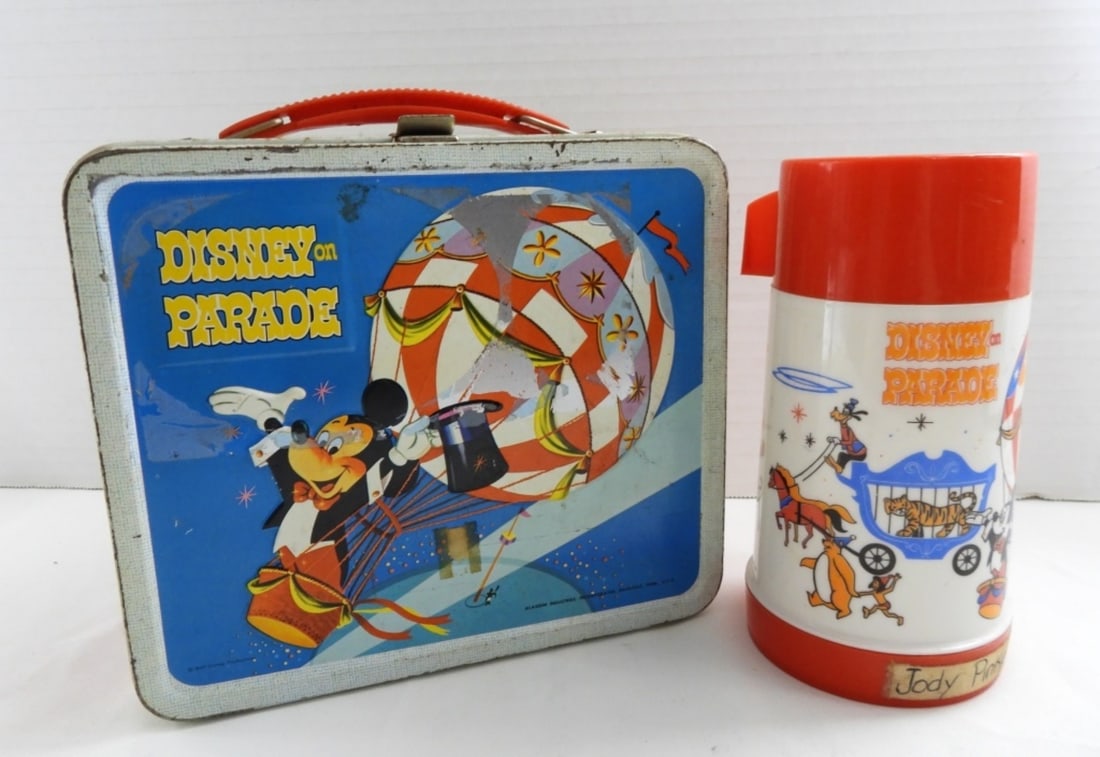 DISNEY ON PARADE LUNCHBOX & THERMOS: DISNEY ON PARADE METAL LUNCHBOX ( THE LUNCHBOX DOES HAVE SOME KIND OF STICKER ON THE FRONT AND THE BACK MAYBE ABLE TO REMOVE.) THE FRONT AND BACK OF THE LUNCH BOX HAS GOOD COLOR, BUT DOES SHOW WEAR IT