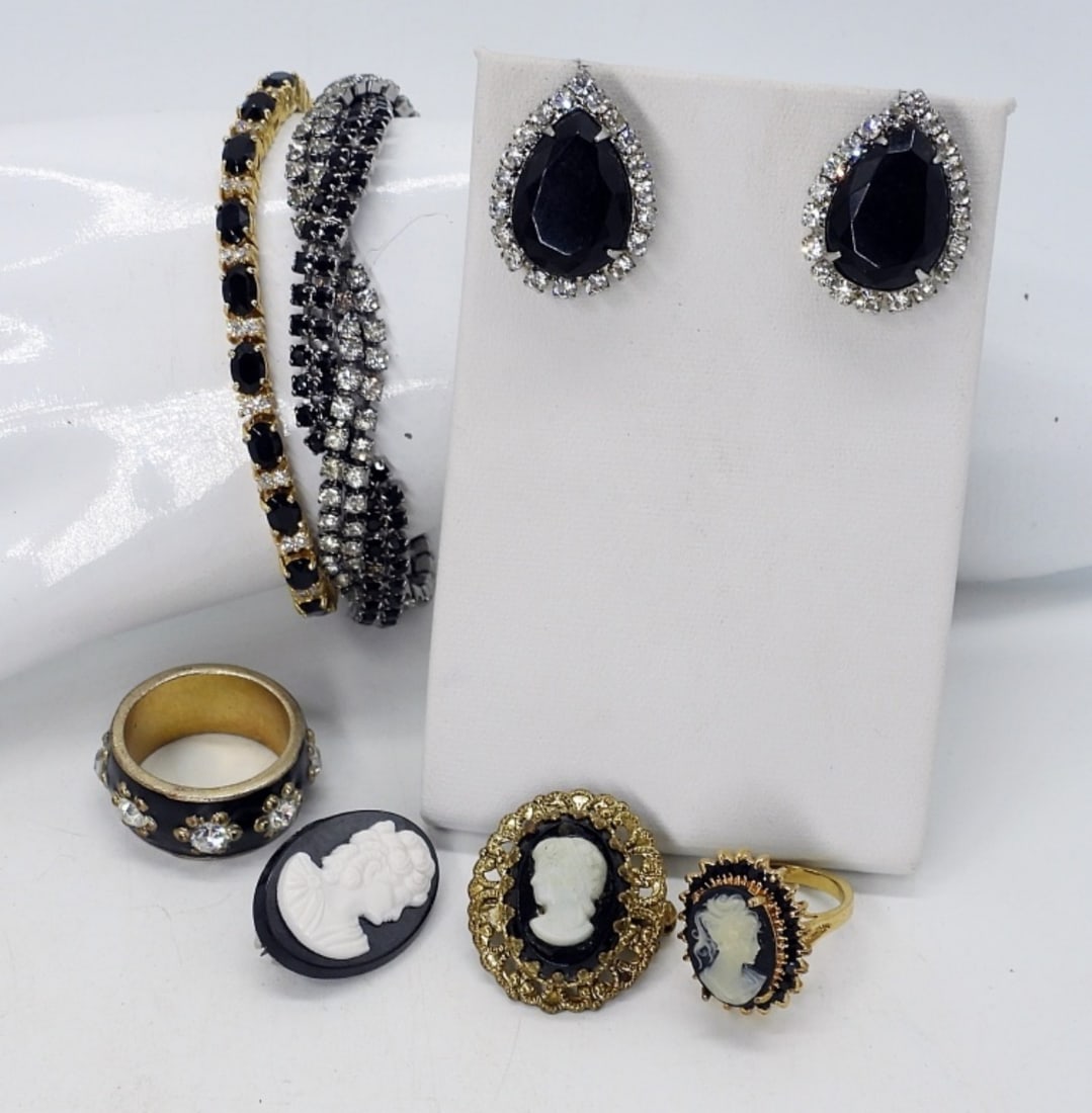 BLACK CAMEO SET & RHINESTONES: TWO RINGS, 5 & 9. 2 PINS. ONE PAIR PIERCED EARRINGS ( NO BACKS). TWO BRACELETS, 7".