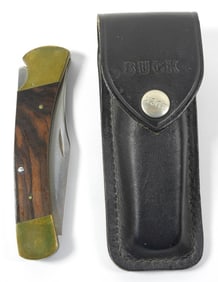 110 BUCK FOLDING KNIFE IN BLACK SHEATH