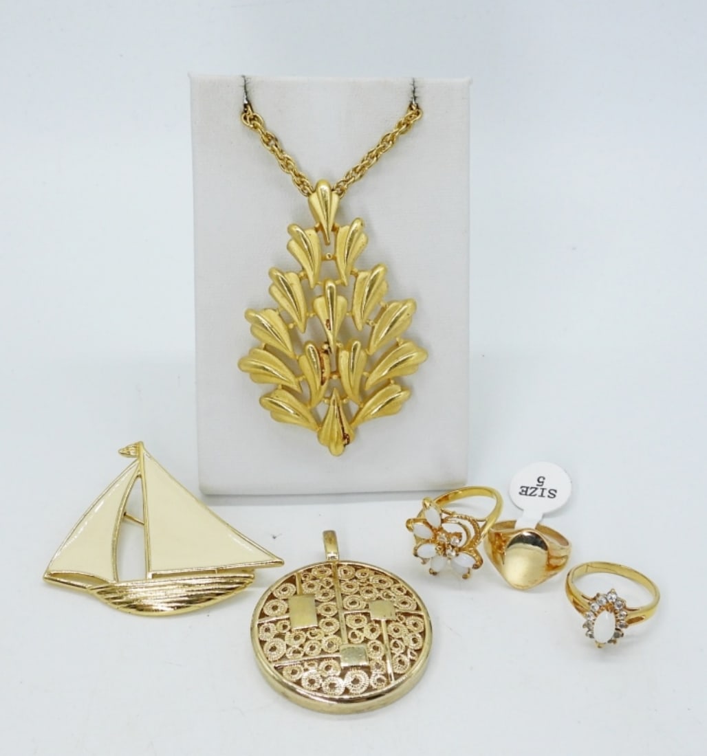 TRIFARI & COVENTRY FASHION PIECES: TRIFARI GOLD TONE PENDANT (3") ON A 30" CHAIN. SARAH COVENTRY GOLD TONE PENDANT (2"). TRIFARI SAILBOAT PIN 2". THREE RINGS, SIZES 5 & 6.
