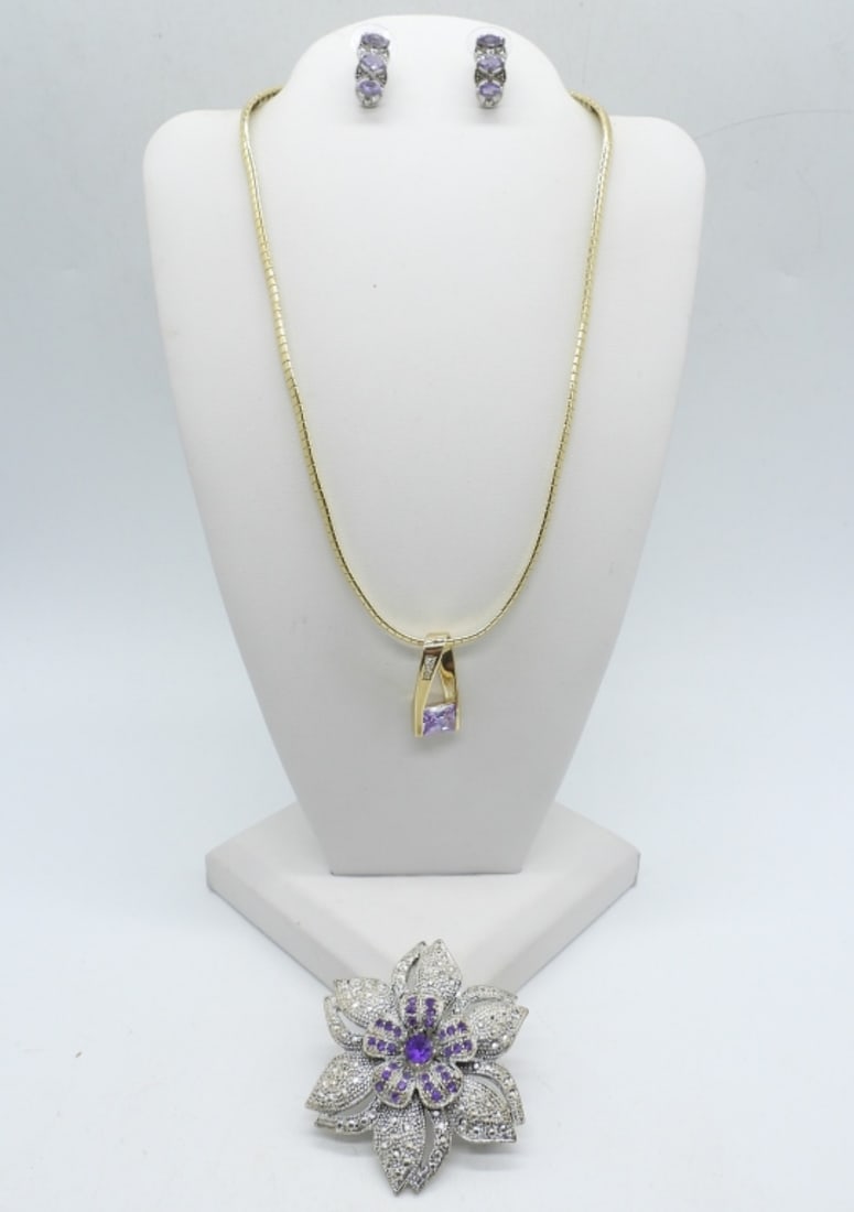PRETTY PURPLE GEMSTONE LOT: GOLD TONE NECKLACE WITH PURPLE GEMSTONE, 16". VINTAGE SILVER TONE FLORAL PIN WITH PURPLE GEMSTONES, 2". PIERCED PURPLE GEMSTONE EARRINGS.
