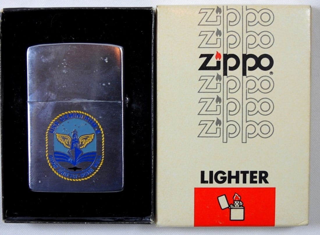 UNFIRED 1982 U.S.S. GEMINI PHM-6 ZIPPO: IN ZIPPO BOX (BOX IS IN GOOD CONDITION) 1982, UNFIRED, SHIP ETCHED ON ONE SIDE, THE OTHER USS GEMINI PHM-6 DONE SWIFTLY, DONE WELL LOGO ON THE OTHER