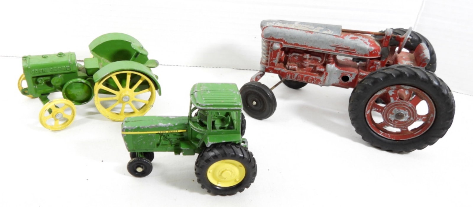(3) VINTAGE CAST IRON TRACTORS: (3) VINTAGE CAST IRON TRACTORS. 2 JOHN DEER TRACTORS AND 1 RED HUBLEY TRACTOR