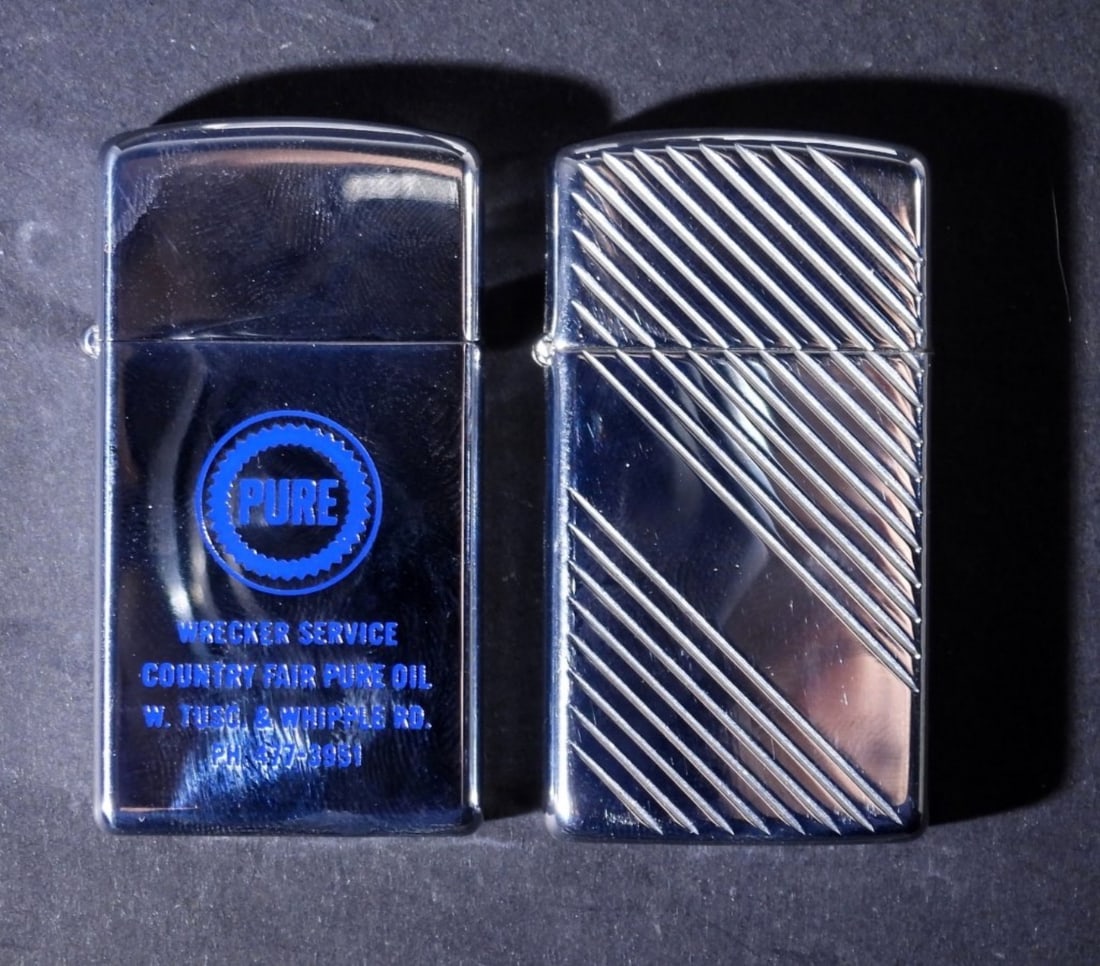 (2) ZIPPO SLIM LIGHTERS IN ZIPPO BOXES: 1- UNFIRED ADVERTISING LIGHTER "PURE WRECKER SERVICE" 1969, 1- FIRED CRISSCROSS DESIGN 2000