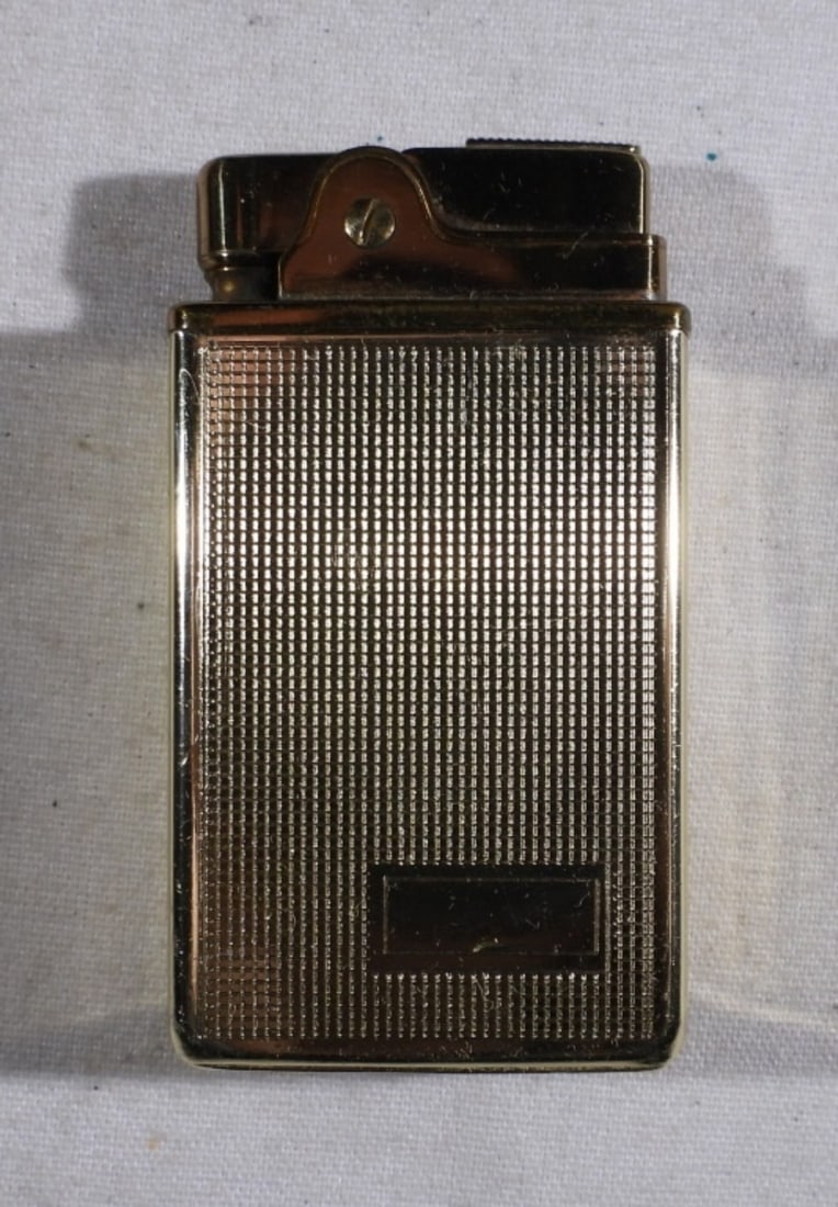 PACTON MUSICAL LIGHTER - GOLD TONE: PACTON GOLD TONE, MUSICAL LIGHTER. COMES WITH A PACTON FELT BAG. MUSIC BOX KNOB DOES NOT TURN. DOES NOT CURRENTLY PLAY MUSIC.