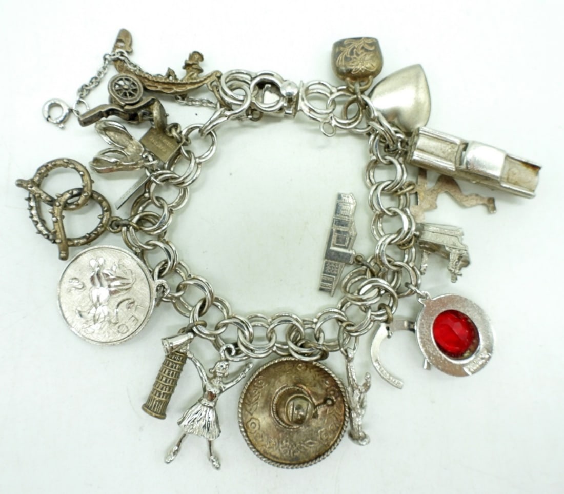 VINTAGE STERLING CHARM BRACELET: VINTAGE STERLING CHARM BRACELET. 17 CHARMS. 7" WITH SAFETY CHAIN. CIRCA 1960's (34.5 DWT)