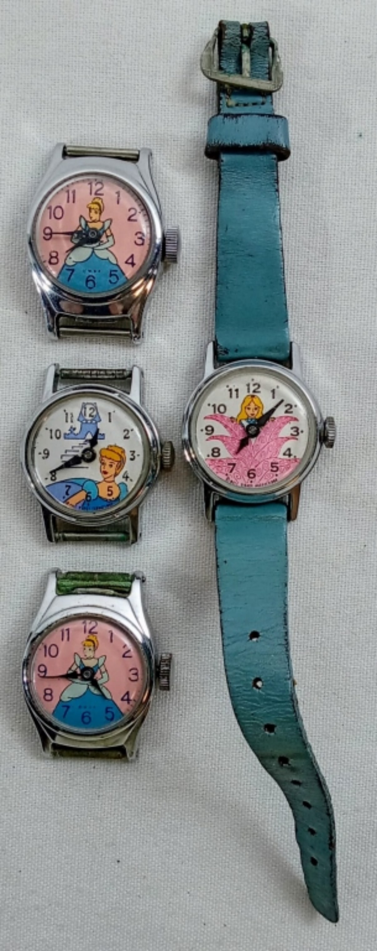 (4) CINDERELLA WATCHES - (1) WITH BAND: VINTAGE WALT DISNEY PRODUCTION LOT - Watches are not verified, authenticated, or tested in running condition unless otherwise specified.