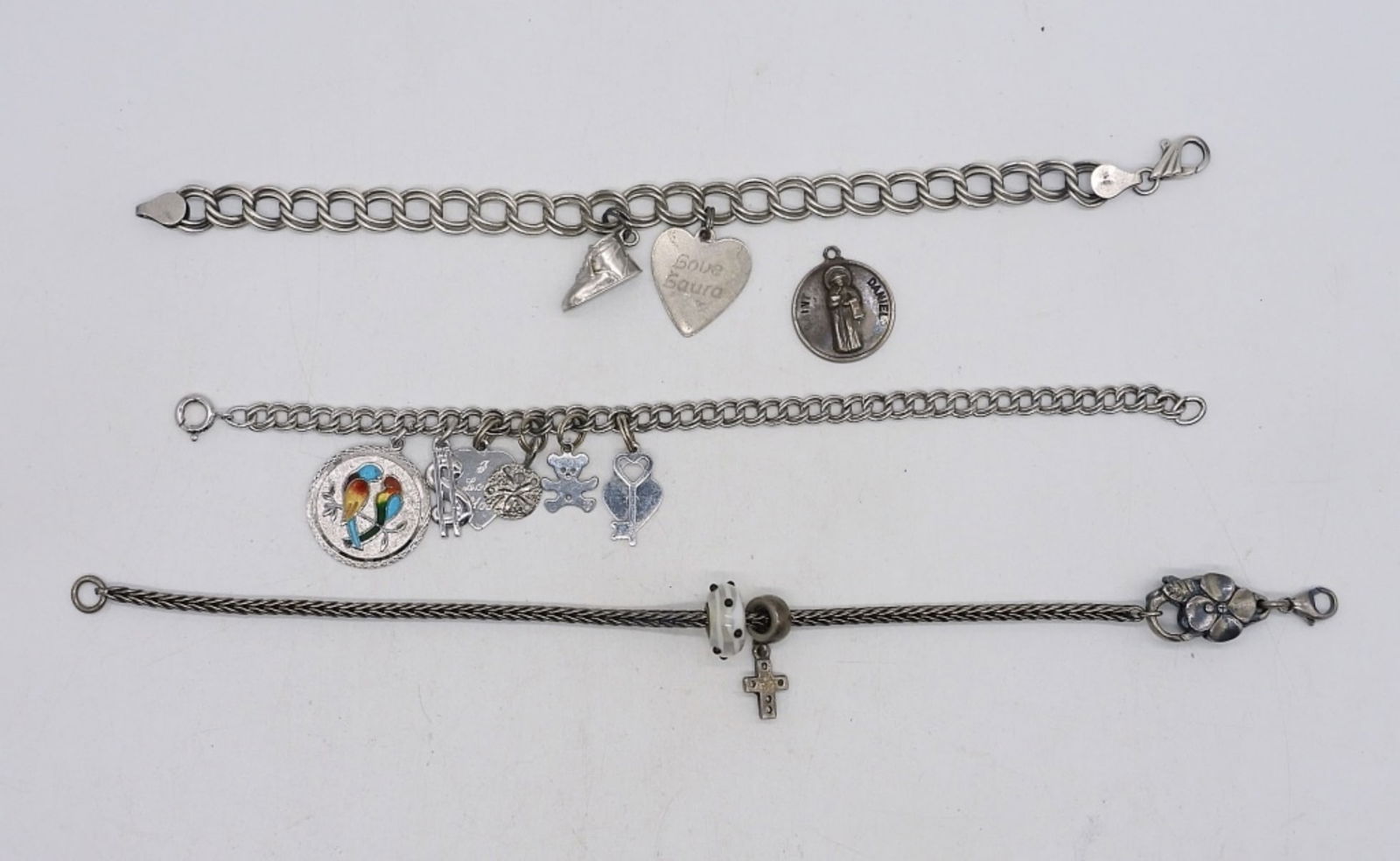 (3)STERLING CHARM BRACELETS: THREE STERLING CHARM BRACELETS. 11 CHARMS. (33 DWT)