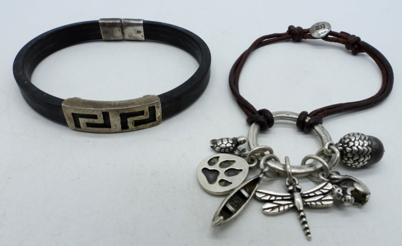 TWO ODD STERLING BRACELETS: TWO ODD STERLING BRACELETS WITH LEATHER AND RUBBER. BLACK ONE HARD TO CLASP. 6-8". (17 DWT)