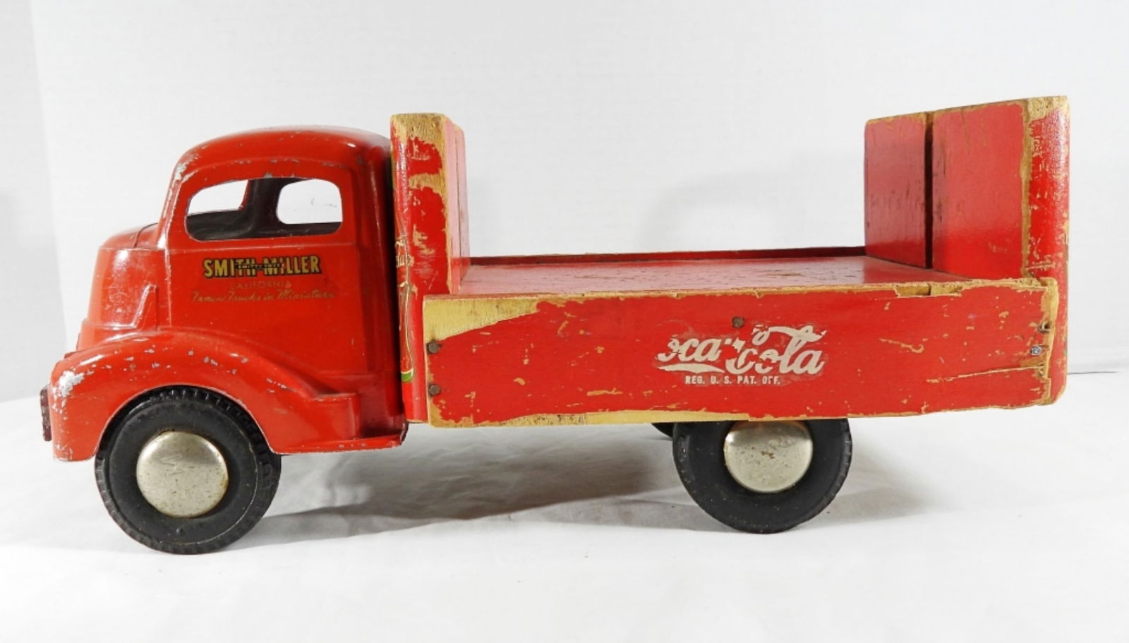 Smith Miller Coca-Cola Truck: A Smithy Toys Smith Miller Coca-Cola Truck. It's missing some wood pieces, and the wood shows some wear. It's in fair condition (pre-owned).