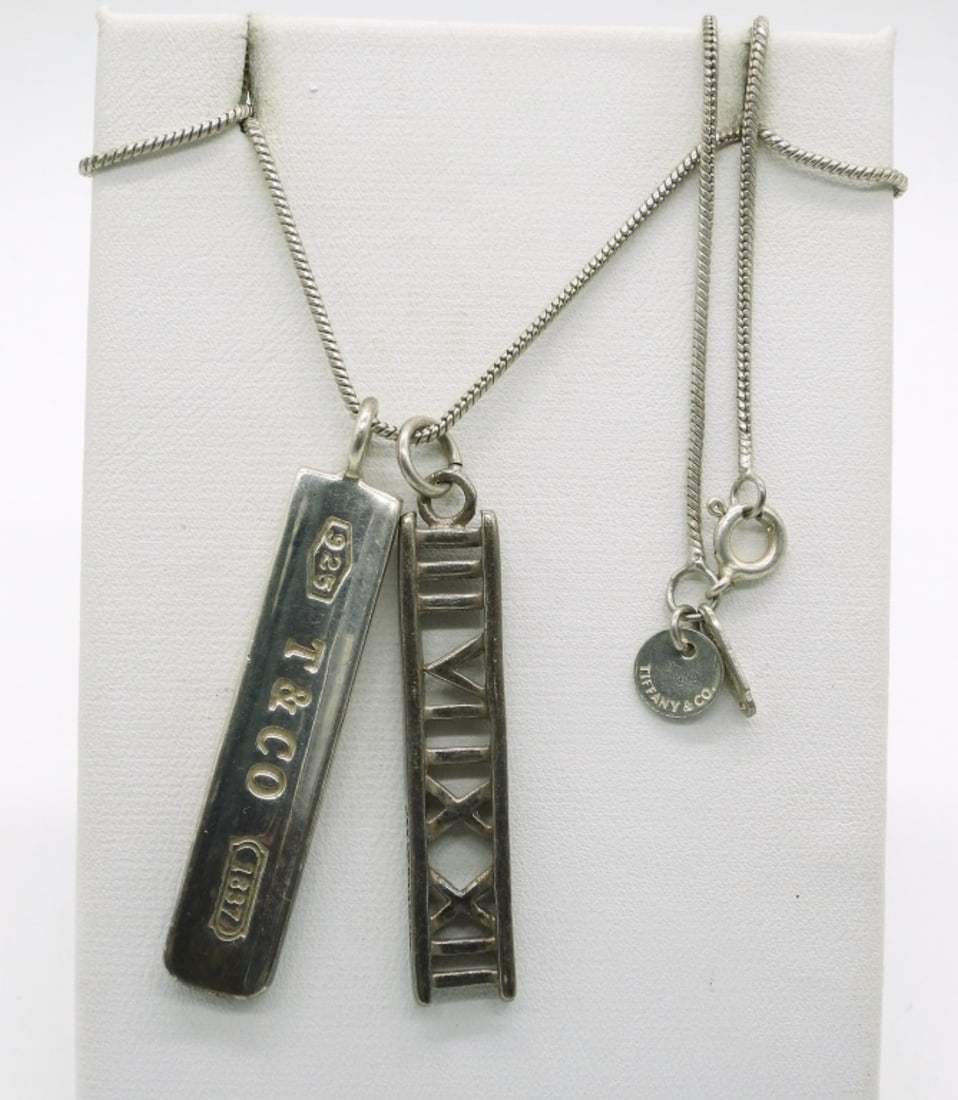 2 Tiffany & Co 925 Pendants, One Chain: Two sterling Tiffany & Co pendants, one Tiffany & Co 22" chain. Bar pendant and Atlas Pendant, both 1 3/4". (8.6 dwt)