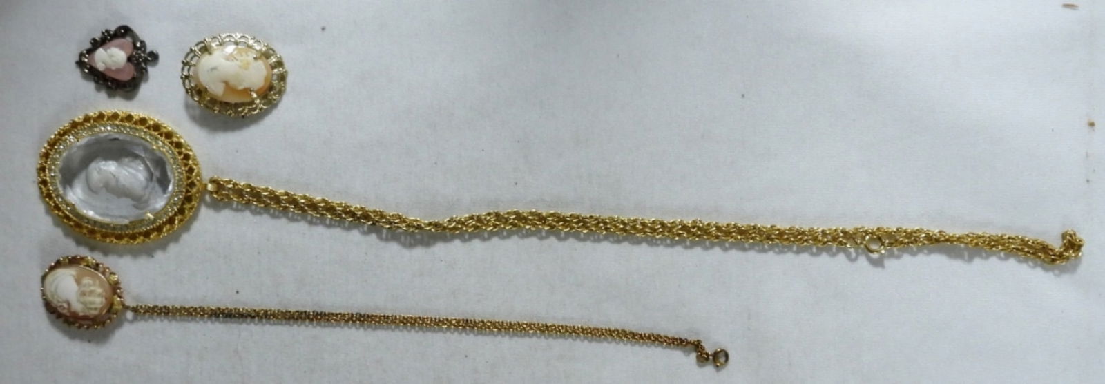 Cameo Necklaces, Pendant & Brooch: 2 cameo necklaces on gold-tone chains, a silver-tone heart-shaped cameo pendant, and a cameo brooch