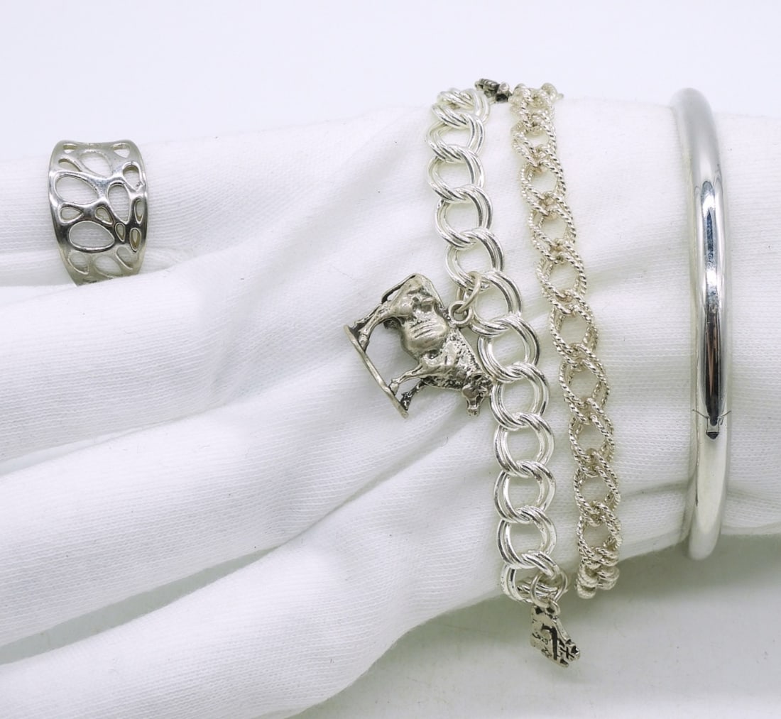 3 Sterling Bracelets & a Ring: 2 Charm bracelets, 4 charms. One hinged bangle bracelet. 6-8". Ring size 8. (25.1 dwt)