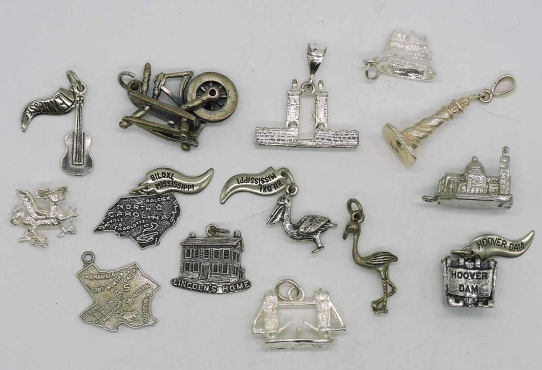 14 Vintage Sterling Charms: Fourteen vintage sterling charms. (28.2 dwt)