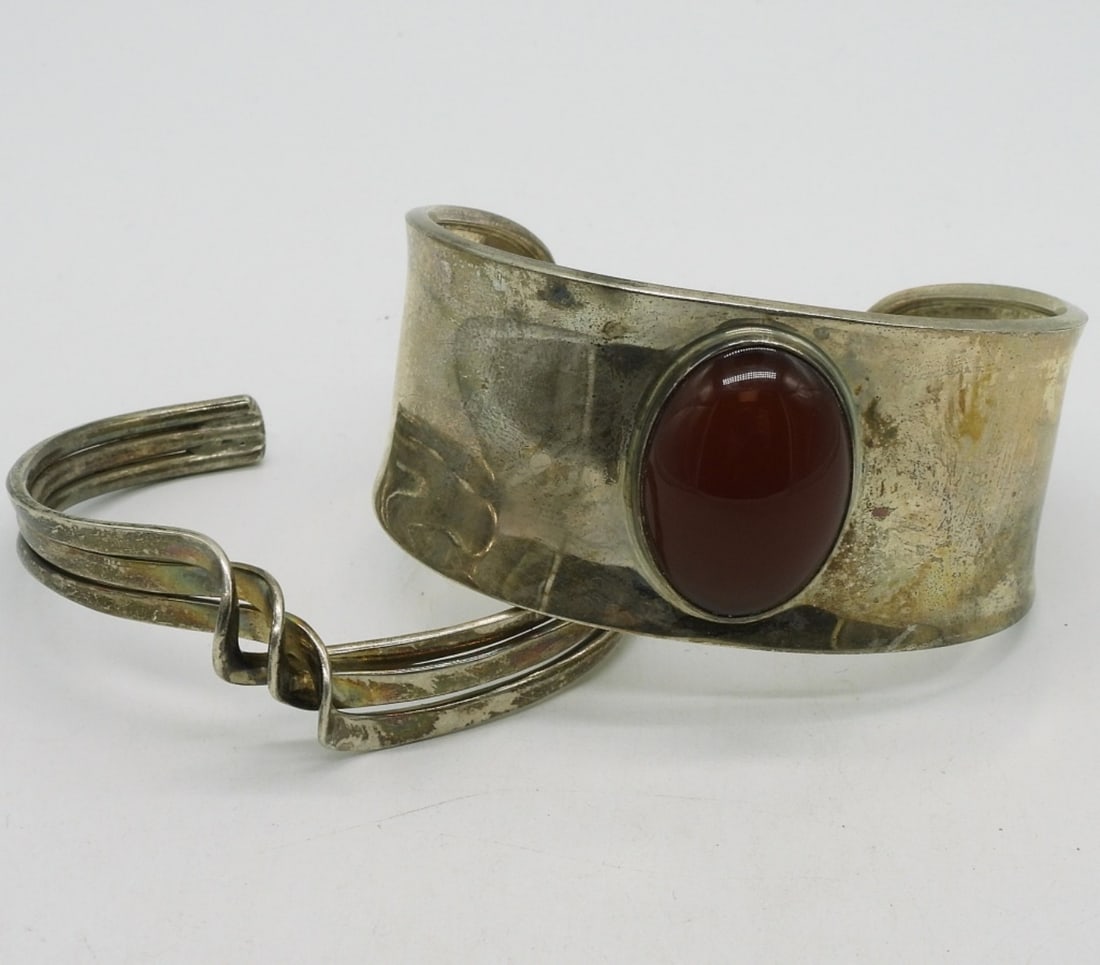 Vintage Sterling Carnelian Cuff Bracelets: Two vintage sterling cuff bracelets, one twisted and one with a large carnelian gemstone. (30 dwt)