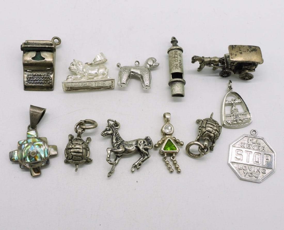 12 Vintage Sterling Charms: Twelve vintage sterling charms. (36.8 dwt)