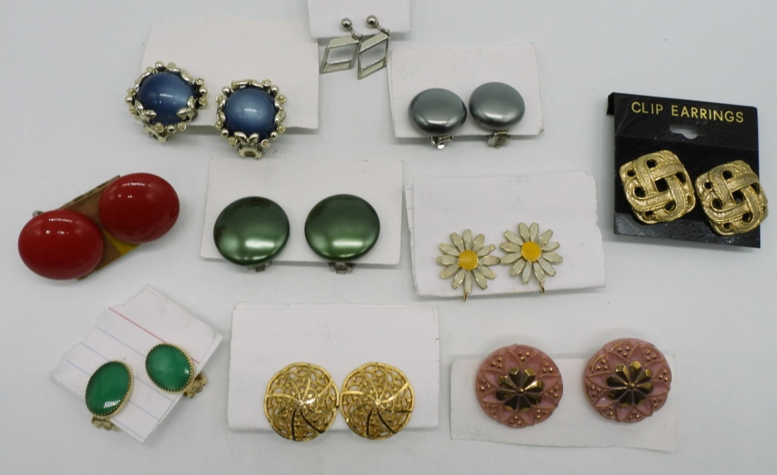 (10) Pair Of Clip On Earrings: Different kinds such as flowers, diamond shape, and red button-like earrings.