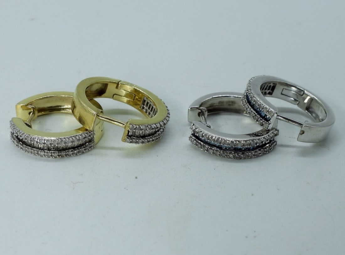 2 Pair Sterling Diamond Pierced Earrings: Two pair of sterling (gold tone and silver tone) pierced earrings. Gold tone pair has white diamonds, silver tone pair has white and blue diamonds. Diamonds have been tested. (5.9 dwt) (6x4x2)