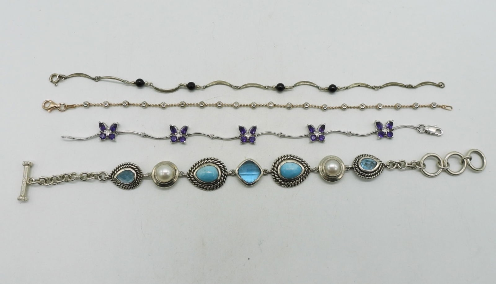 4 Amethyst, Larimar 925 Bracelets: Four sterling bracelets with amethyst, blue topaz & larimar. (25 dwt)