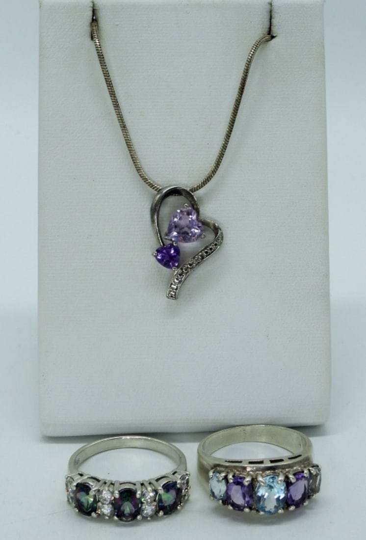 Amethyst, Blue Topaz, Mystic Topaz Rings: Two sterling rings with amethyst, blue topaz and mystic topaz gemstones. Size 10. Amethyst sterling heart shaped necklace, 20" long. (11 dwt) (6x4x2)