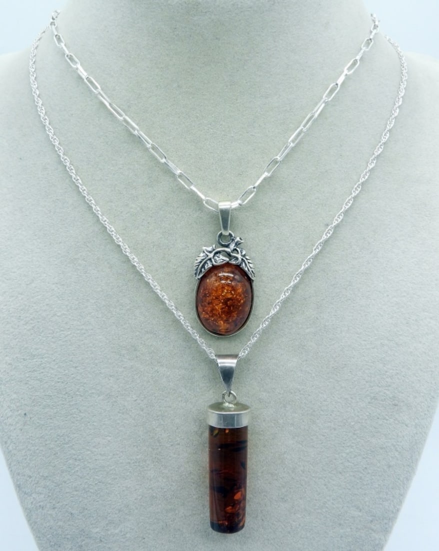 Two Sterling Amber Necklaces: Two sterling necklaces with Amber gemstone pendants. Chains are 16" long. Pendants are 1.5" & 2" long. (8.5 dwt)