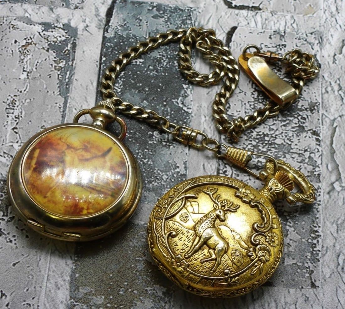 (2) Deer Pocket Watches: 1) Dickes. With a chain.. 2) Hautman Brothers. Watches are not verified, authenticated, or tested in running condition unless specified.
