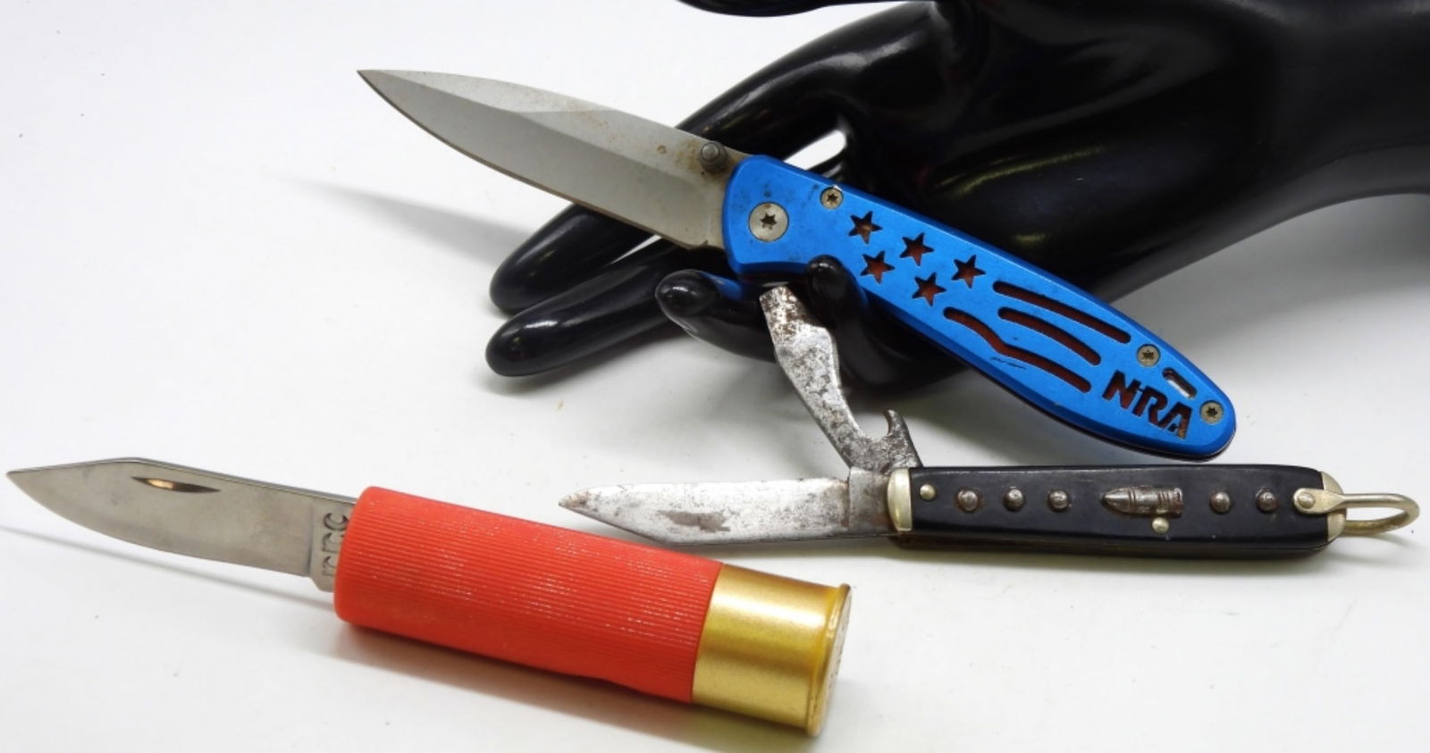 (3) Gun Enthusiast Pocket Knives: 1) Lone Ranger 1940s Black Pocketknife w/Silver Bullet 2) Blue flag NRA knife. 3) Shotgun shell novelty knife