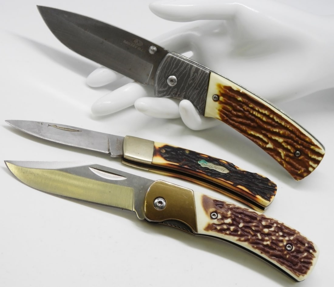 (3) Lock-Back Knives With A Stag Handle: 1) Schrade 5UH Uncle Henry. 2) Isn't marked. It does have a belt clip. 3) Mossy Oak lock-back