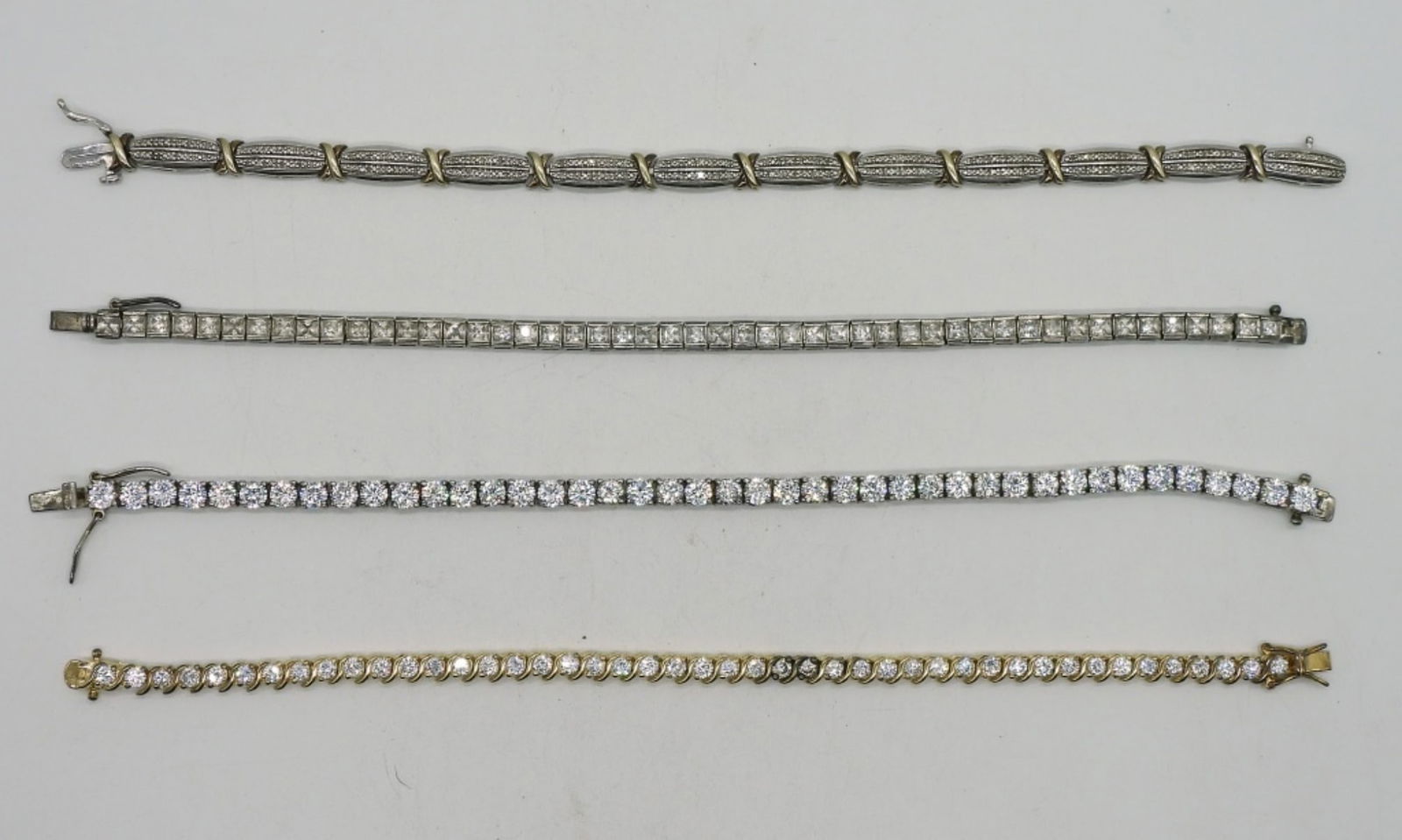 4 Sterling Tennis Bracelets: Four sterling tennis bracelets, simulated diamonds. 7-7.5" long. (29 dwt)
