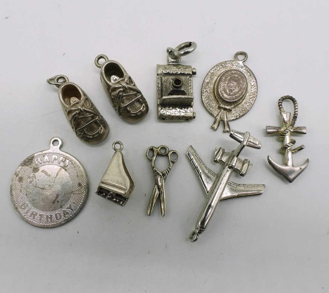 9 Vintage Sterling Charms: Nine vintage sterling charms. (18.4 dwt)