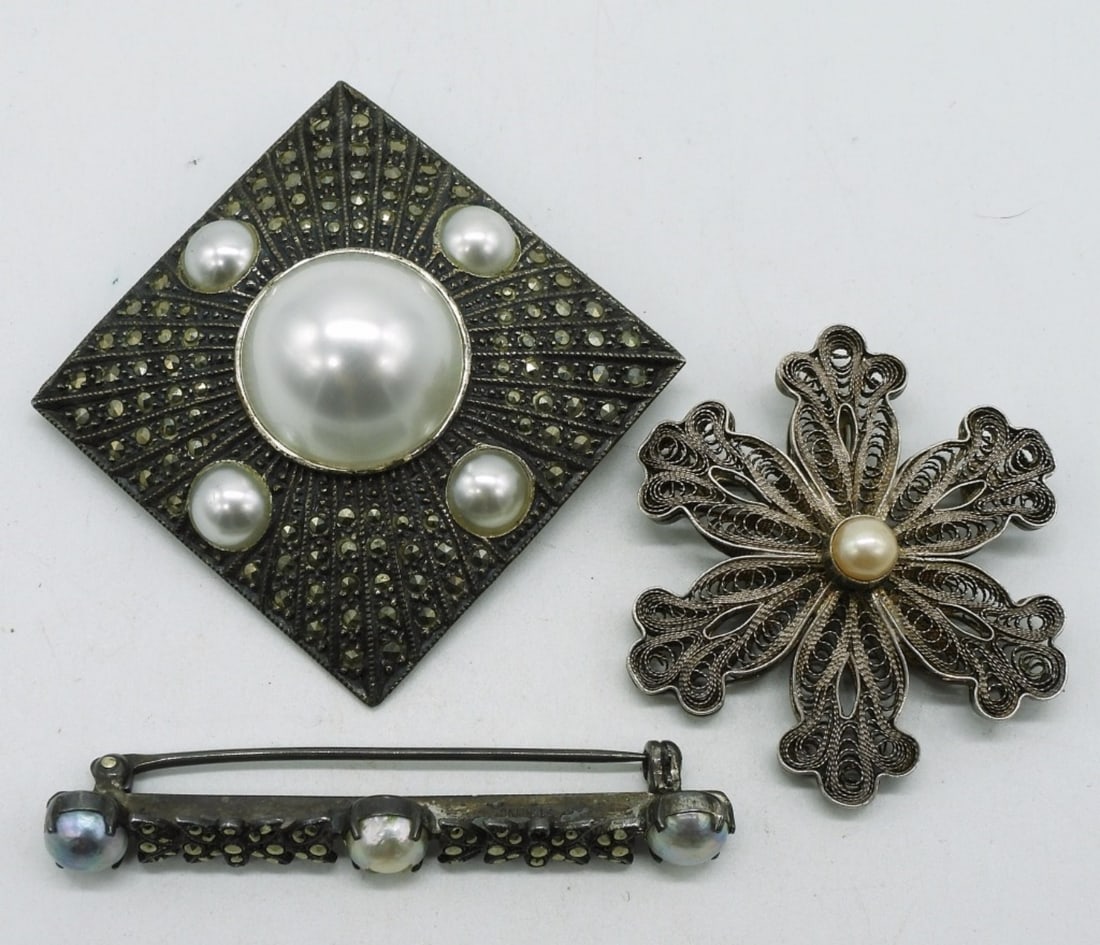 3 Sterling Marcasite Pearl Vintage Brooches: Three sterling brooches with pearl and marcasite accents. 1.5" - 2.5". (24 dwt)