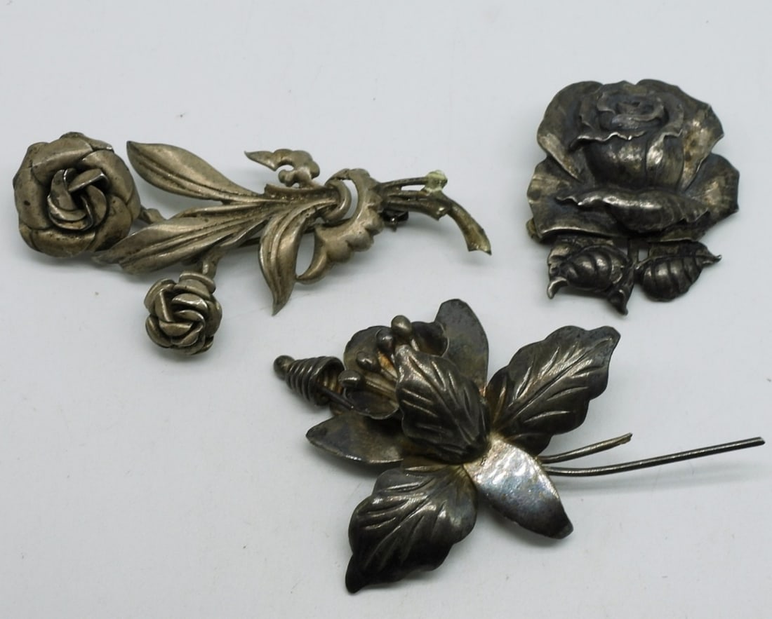 Cini Sterling Rose Brooch & Two Others: Cini brand, sterling rose shaped brooch, 1.5" long. Two other sterling flower brooches, 3" long. (19.8 dwt)