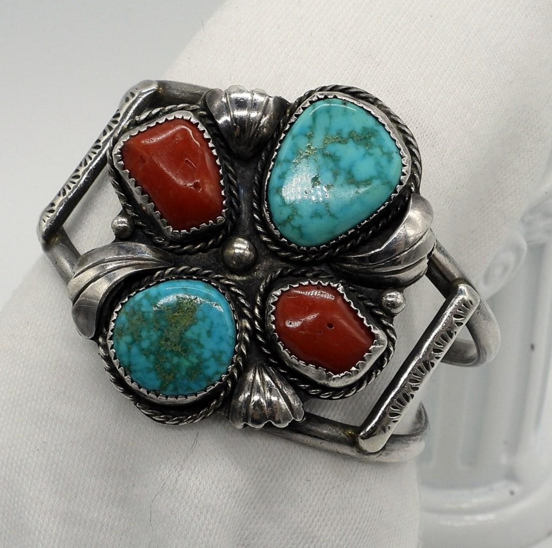Native American Cuff Bracelet with Turquoise: Large floral design, sterling cuff bracelet. Turquoise and Red Coral gemstones. Face of bracelet measures 2" x 1.5". See photo for stamp. (22.8 dwt)