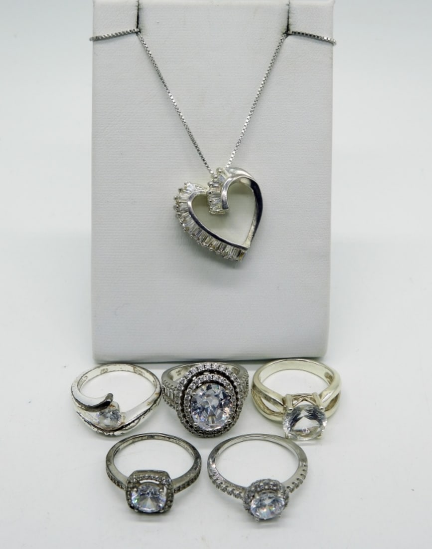 Bridal Style 925 Rings and Necklace: Five sterling bridal style rings (simulated diamond, cz & glass), sizes 6, 7, 8. Sterling heart shaped pendant, 1" long, on a 18" sterling chain. (17.5 dwt)