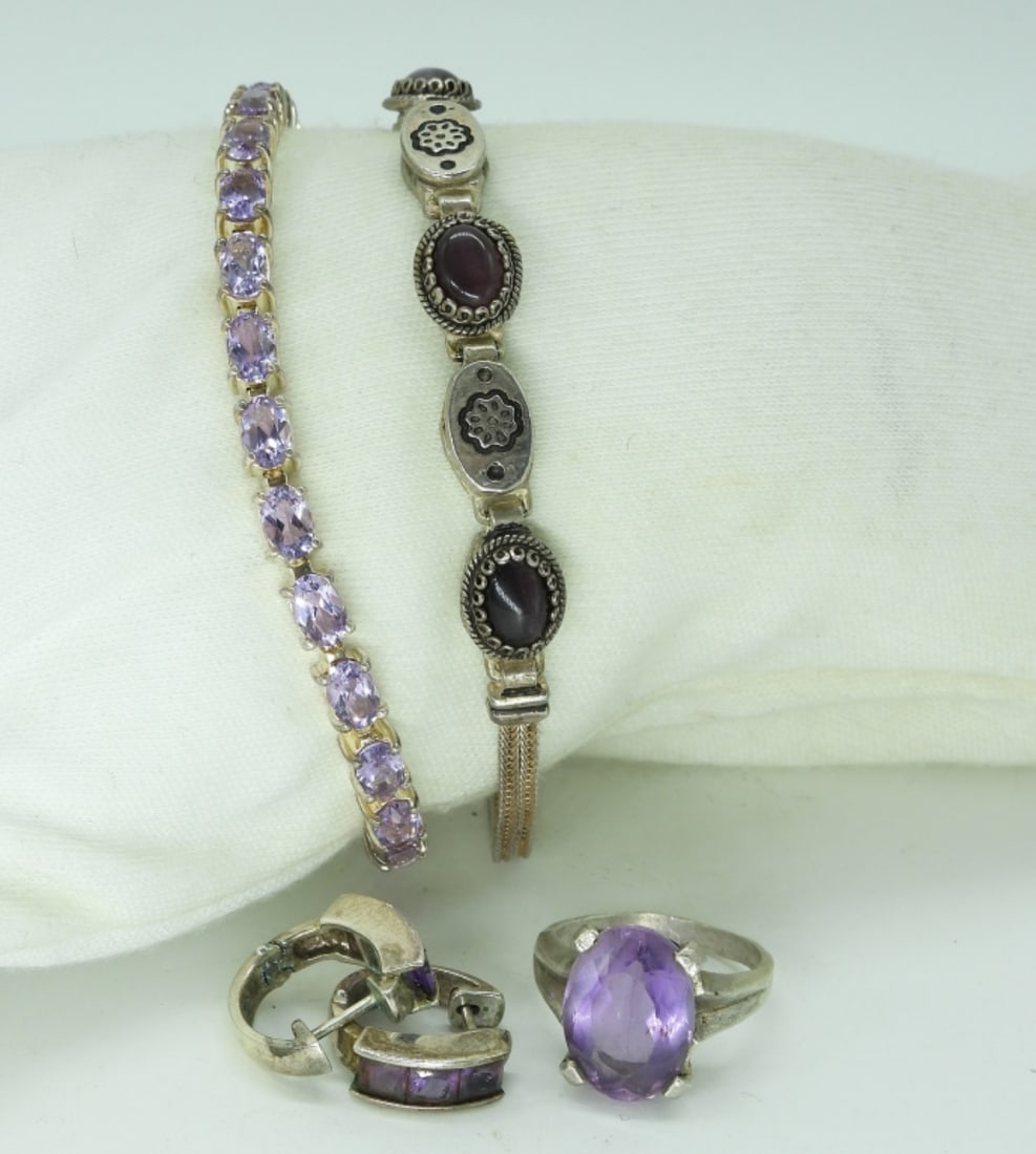 Amethyst & Sterling Bracelets & More: Two sterling bracelets with amethyst and purple cats eye, 7.5" long. Pierced amethyst earrings. One ring, size 7. (24 dwt)