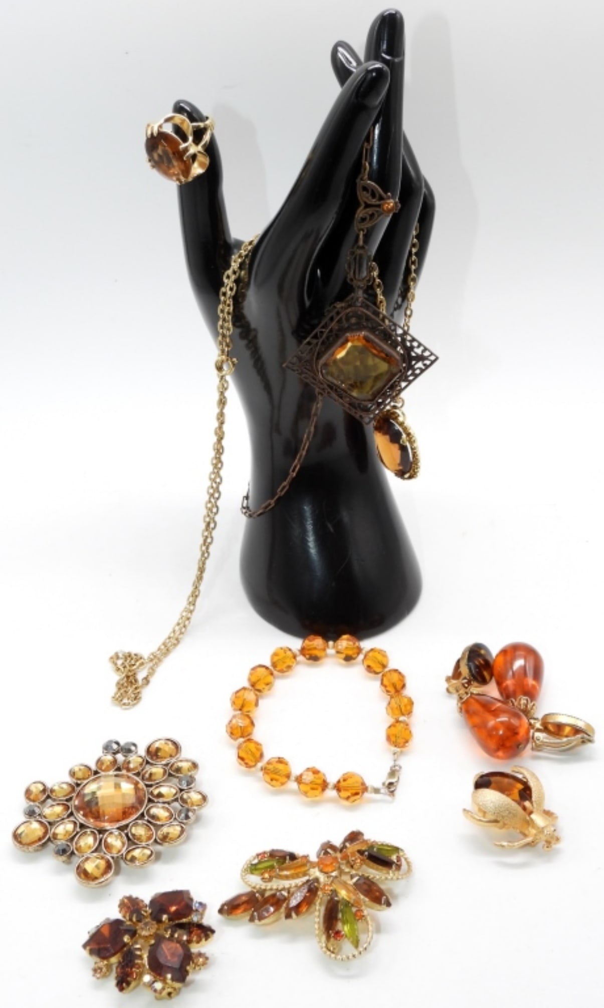 Amber Colored Lot: (2) Necklace (1) Bracelet (1) Ring size:4.5 (4) Brooches (1) Pair of clip-on earrings
