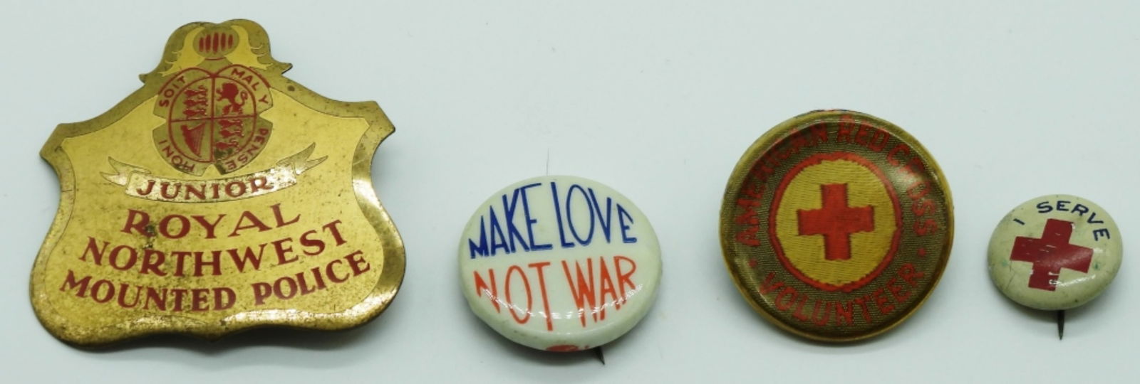 (4) Mixed Lot Of Pins: (2) Red Cross volunteer pins. (1) Make Love Not War. (1) Junior Royal Northwest Mounted Police