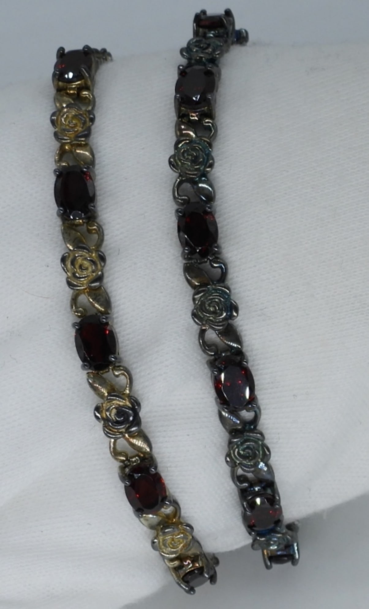 Sterling & Gold Tone Garnet Bracelets: Two sterling and gold tone sterling rose design bracelets with Garnet gemstones. Both are 8" long. (18 dwt)