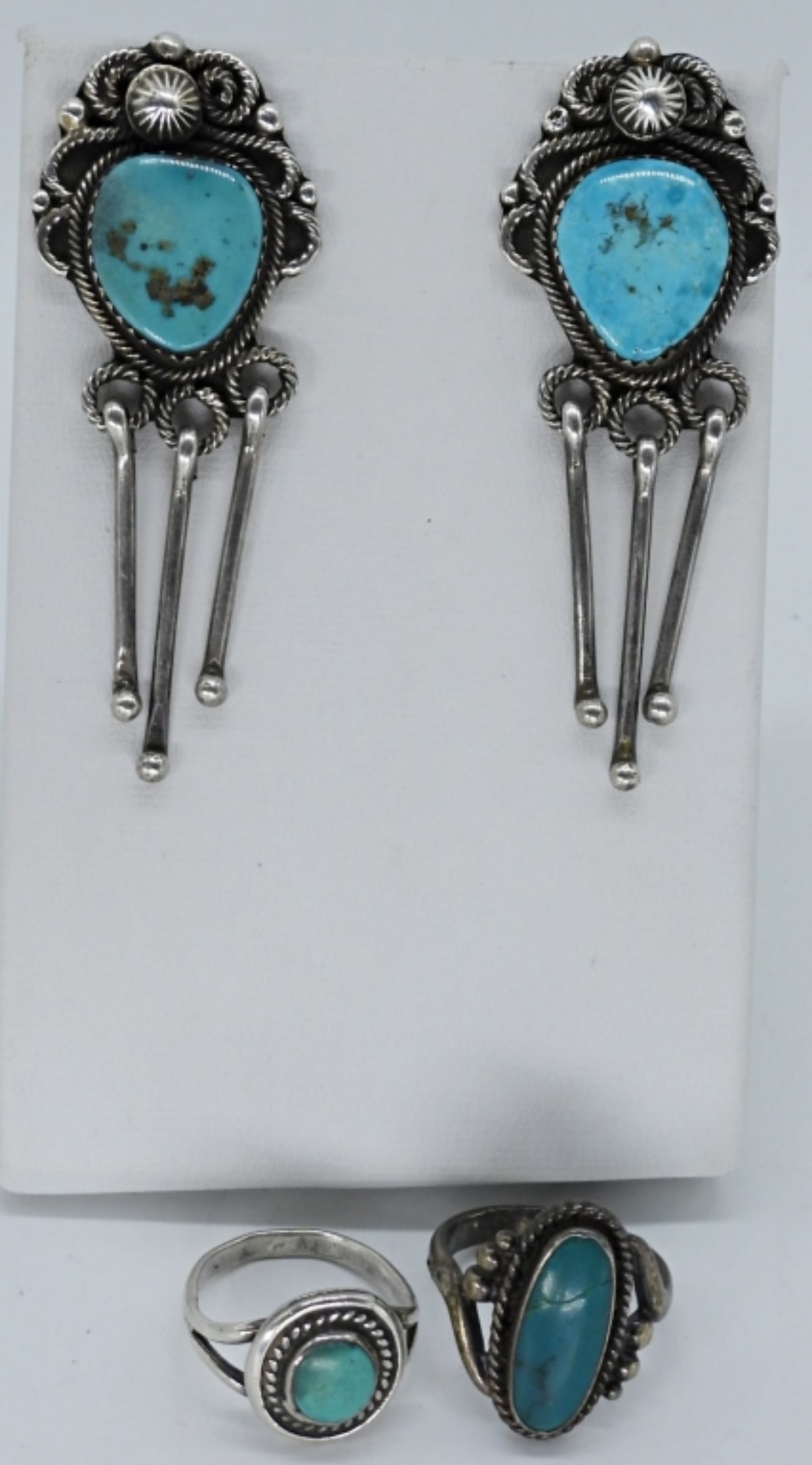Val Tsosie Navajo 925 Earrings & Rings: Navajo artist, Val Tsosie signed sterling earrings with turquoise gemstones, 2" long. Rings are size 4.5 & 5.5 (13 dwt)