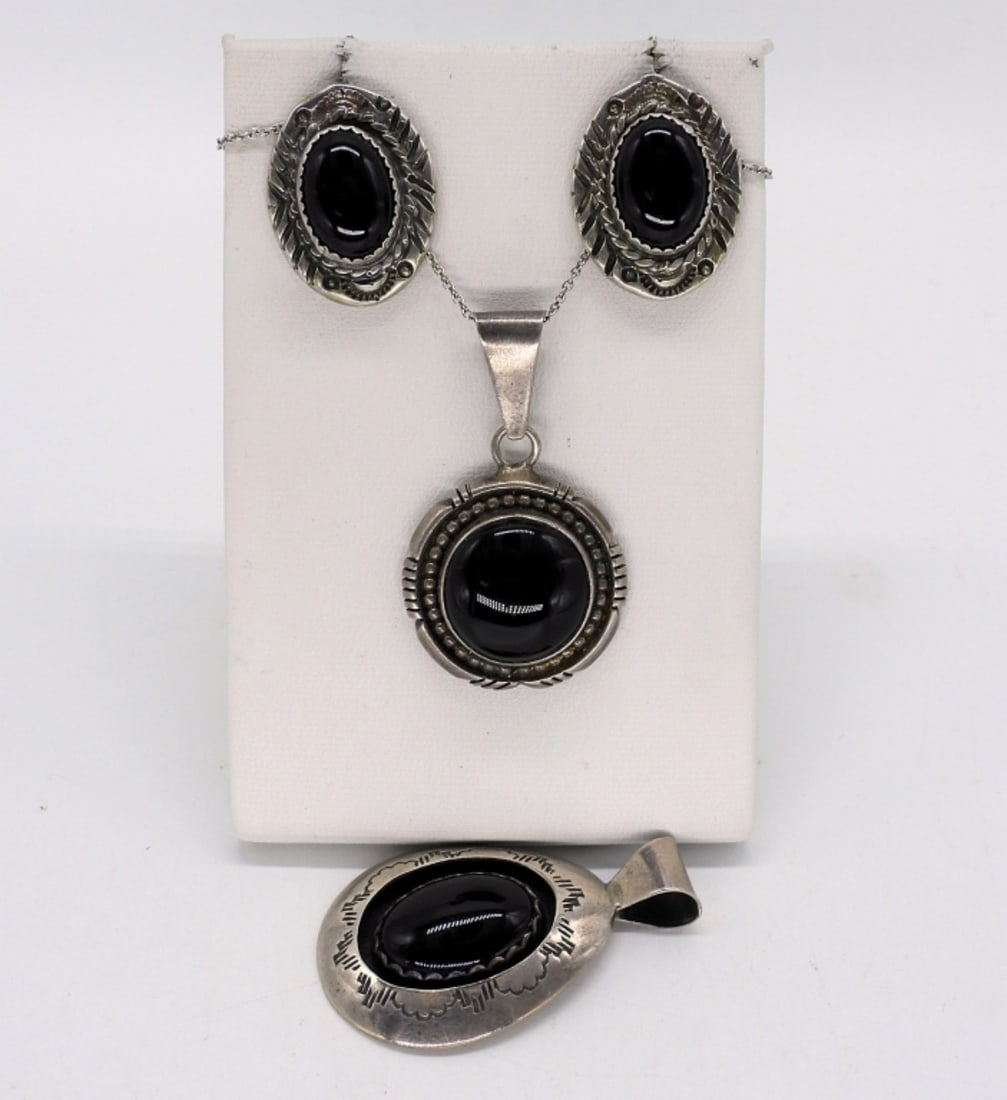 Navajo Sterling Black Onyx Pendants & More: Two sterling Navajo pendants with black onyx gemstones. Pendants measure 1.5" long. Pierced sterling earrings with black onyx, 1" long. Sterling chain is 18" long. (17 dwt)