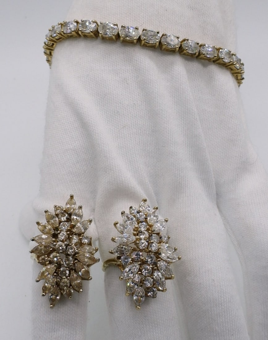 Gold Tone 925 Diamond Like Rings & More: Two sterling gold tone rings, identical other than gemstone color. Simulated diamond gemstones, clear and champagne colored. Sizes 5 & 7. Gold tone simulated diamond bracelet, 7.5" long. (17 dwt)