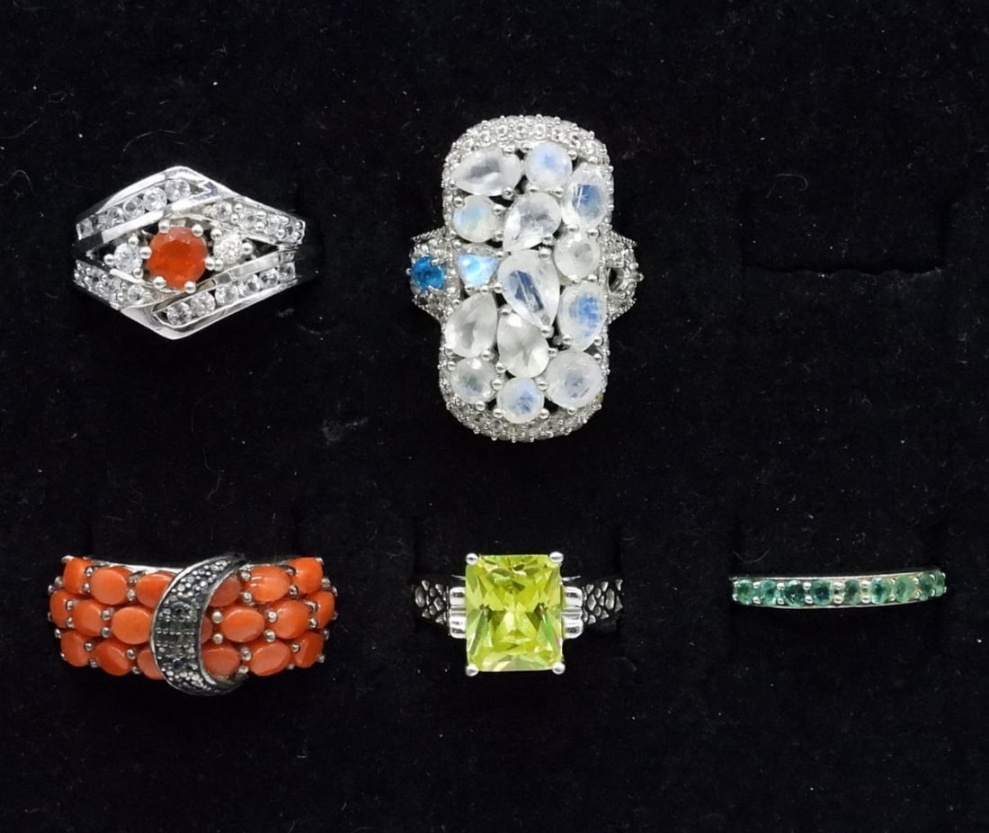 5 Odd Sterling Gemstone Rings: Five odd sterling gemstone rings. Peridot, Blue Topaz, Red Coral, Moonstone & Orange (unidentified) solitaire. Rings are all size 7. (14.5 dwt)