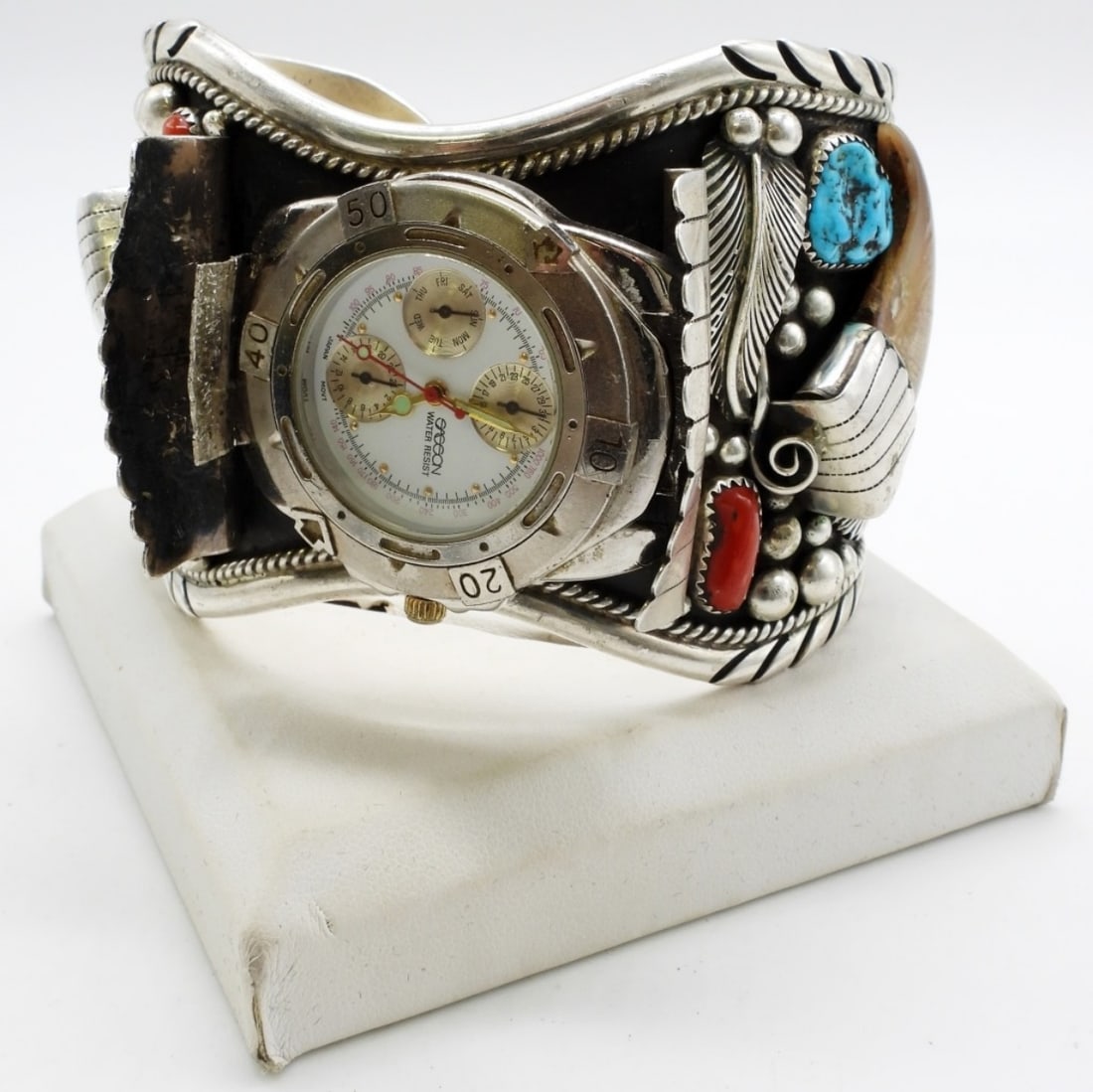 Large Sterling Navajo Watch Cuff 120DWT: Sterling Navajo watch cuff. It is stamped sterling inside the cuff. About 7in with a gap. Does have a watch face that can come off. Coral and Turquoise. Watches are not verified, authenticated,