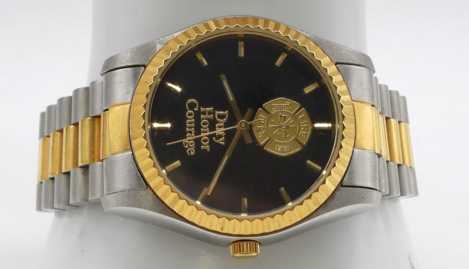 Bradford Exchange Firefighter Department Watch: Two-tone. Quartz movement. Has a firefighter logo, with the words "Duty Honor Courage." Watches are not verified, authenticated, or tested in running condition unless specified.