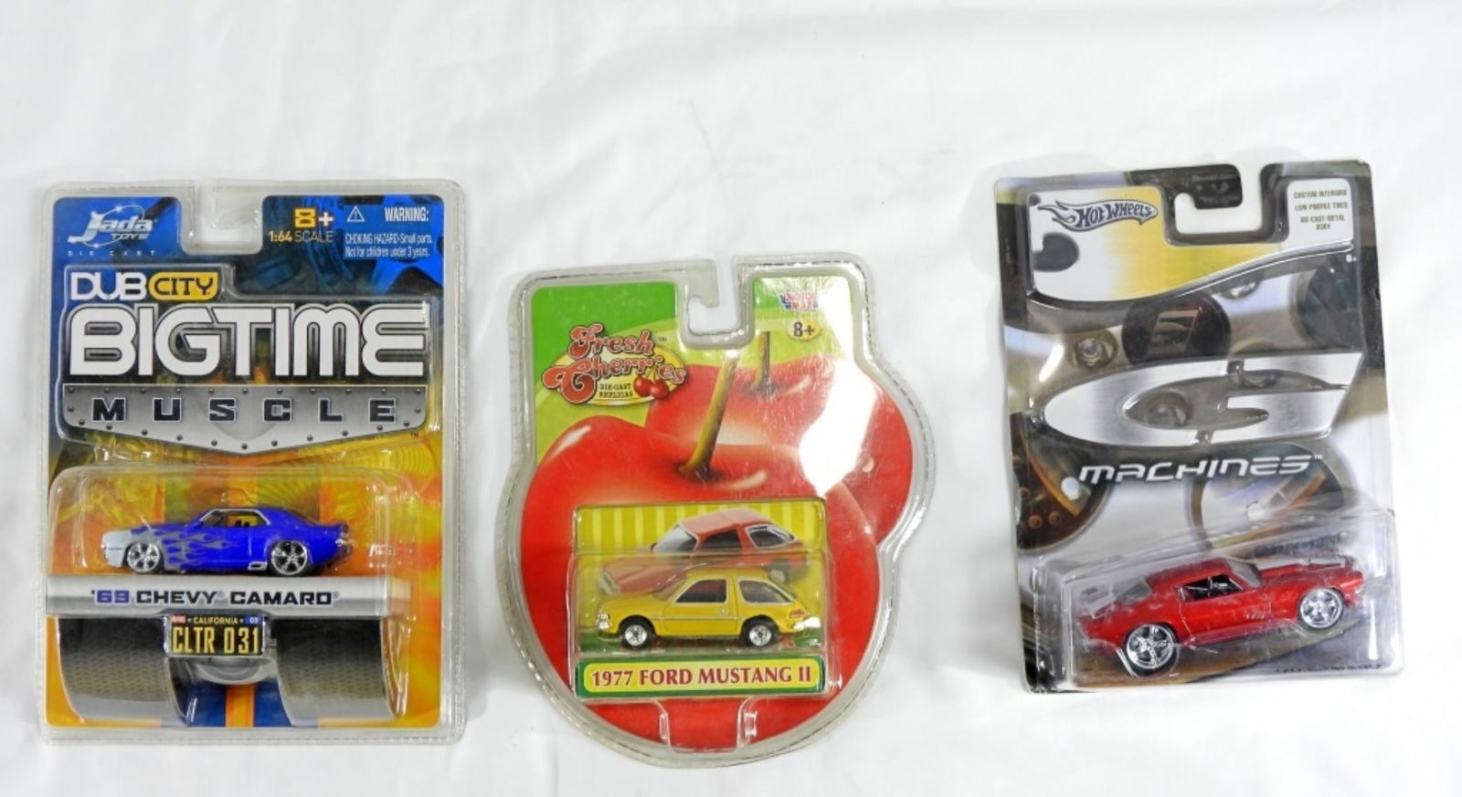 Mixed Lot Of 3 Cars: The 1st car is a DUB City Bigtime Muscle 1969 Chevy Camaro, the 2nd car is a Motor Max Fresh Cherries 1977 Ford Mustang II, the 3rd car is a Hot Wheels G MACHINES 70' CAMARO. All packages are in