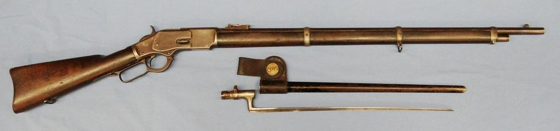 Win. 1873 musket w/bayonet and case, .44-40, 30" rd.: Win. 1873 musket w/bayonet and bayonet sheath, .44-40, 30" rd. bbl, bright bore, 21" bayonet, sling swivels, s#369869B, made 1891. Bayonet brass medallion marked N.G.P. Video available on this lot. Vi
