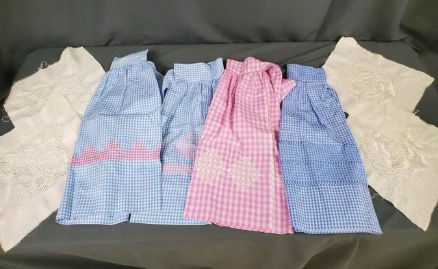 Group of Vintage Aprons and more: Group of 4 vintage half aprons in gingham fabric: 3 blue, 1 purple, each with hand embroidery. All are in very good condition, only 1 has a small spot. Along with 4 linen squares with hand embroidery,