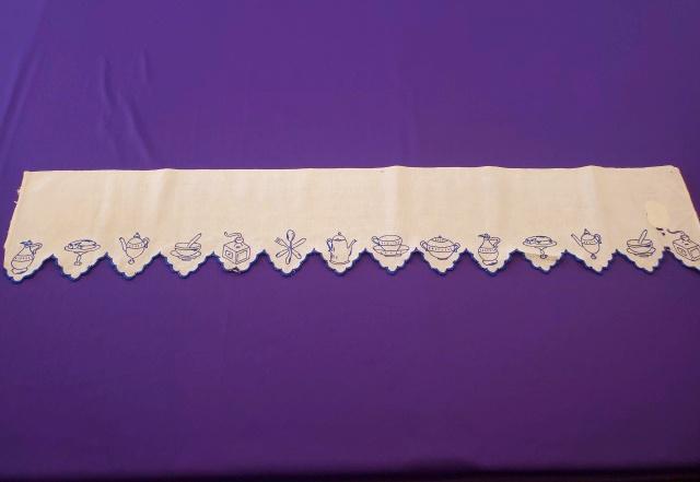 Vintage Blue Embroidered Kitchen Valance: Vintage cotton kitchen valance or other decorative piece measuring 8.5x47 inches. Hand embroidered in blue thread with various kitchen items: tea cup, pot, coffee grinder, sugar bowl, cake on a stand,